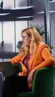 Vertical Woman CEO dealing with headache from burnout in a modern office space, discussing business growth and strategic planning. Leader emphasizing corporate feminism and gender equality. Camera B. video