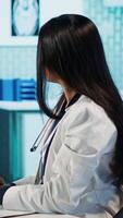 vertical indiano médico entrando uma ligar com especialista para discutir diagnóstico relatório, Perguntando a especialista para uma segundo opinião em controlo remoto Videoconferência. médicos encontro conectados para telessaúde. Câmera uma. video