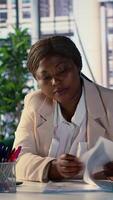 Vertical Empowered black female CEO working on career development strategy, multitasking in order to increase enterprise profit. Decision making leadership skills for productivity and work ethic. Camera A. video
