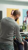Vertical Middle eastern employee assisting client to choose from the new collection of items, presenting higher fabric quality and potential color assortments. Professional retail experience. Camera A. video