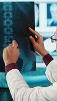 Vertical Professional doctor and patient engage in a medical check up for a scan interpretation of x ray and MRI results. General practitioner emphasizing healthcare practices and medical research. Camera A. video