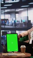 Vertical Group of professionals using isolated chroma key on tablet in a meeting, sharing insight on their companies ideas. Powerful business experts planning a growth strategy. Camera B. video