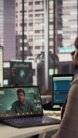 Vertical Black director discuss on a call with business consultant for a new strategy, uses remote communication on online conference to establish objectives. Connection with specialist. Camera B. video