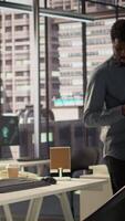 Vertical Black analyst working with monthly revenue balance to create financial plans using online tools, analyzing data infographics. Businessman managing organizational goals for efficiency. Camera B. video