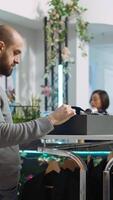 Vertical Middle eastern retail assistant guiding client in choosing a tie, looking to buy luxurious accessories for a special event. Male customer discussing about quality and fashion trends. Camera B. video