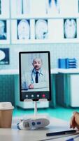 Vertical General practitioner discussing with a doctor on conference call, reviewing test results diagnosis and sharing records. Indian medic searching treatment against disease, telehealth. Camera B. video