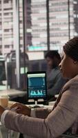Vertical Female boss with chronic disability examining archived files and data reports, creating a financial plan before allocating resources. Businesswoman in wheelchair review infographics. Camera B. video