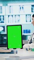 Vertical Specialist discussing x ray imaging with a patient next to isolated mockup display, presenting healthcare diagnosis during check up visit. Physician sharing the treatment plan and advice. Camera B. video
