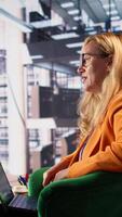 Vertical Determined businesswoman speaking on a phone call to ensure project development success, multitasking in a corporate office. Female CEO using remote connection on her smartphone. Camera B. video