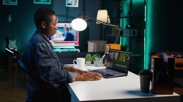 editor selecting key frames to use while doing montage, working from home on notebook device. Woman using mouse to edit movie project footage in apartment office, camera B video