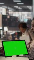 Vertical Confident woman at desk managing business tasks next to copy space, reviewing financial reports for decision making. Black employee reviewing data for growth and effective management. Camera B. video