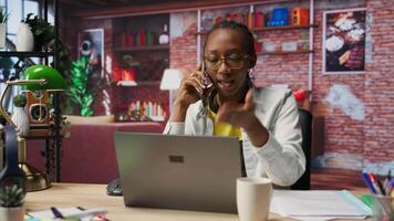 Irate manager in apartment berating employee during phone call, looking at laptop. Team leader scolding worker during telephone call after finding errors in documents, closing notebook in anger video