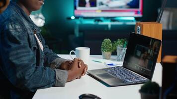Remote worker talks with board of directors during videocall business meeting from home office. Teleworker speaks in remote videoconference telework call, receiving feedback from management, camera A video