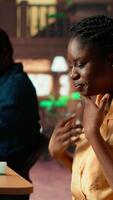 Vertical Overwhelmed upset girl struggling to study for an upcoming exam, trying to memorize the theoretical notes from the class course at the library. Black college student concerned with her grades. Camera A. video