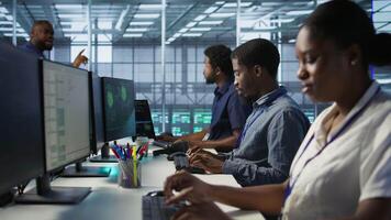 Engineers seeing system hacked popup on PC screen in data center, requesting help from cybersecurity team. Server farm worker seeing security incidents affecting network system, camera A video