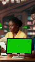 Vertical Black academic pupils studying for educational success next to mockup at a public library, reading research notes and information from books. Team of students prepares for a test. Camera B. video