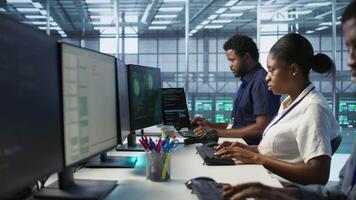 IT staff members seeing critical error popup on PC screen in data center, requesting help from cybersecurity team. Server hub coworkers struggling to eliminate cyberattacks affecting network, camera A video