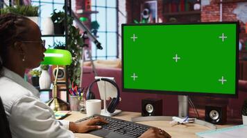Woman enjoying leisure time at home, using green screen computer to text friends. Person talking with mates on social network online website, using mockup PC monitor, camera A video