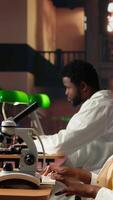 Vertical University scholar focuses on examining chemical processes and microorganisms for medical science career. Woman studying in the library to support her educational development. Camera A. video