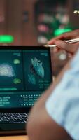 Vertical Med school student takes personal notes from anatomy research papers, studying healthcare methods for a medical career. Male scholar using books from the campus databases. Camera B. video