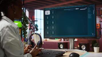 Woman in apartment workspace using AI software turning text prompt into photos and listening music. Person in brick wall home wearing headphones uses text to image generative models on PC, camera A video