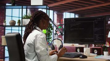 IT technician in home office looking at UI on computer monitor, executing programming script. Remote employee using coding application to write and test code in modern apartment, camera A video
