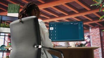 Woman at home using generative artificial intelligence website generating videos using diffusion models. Person drinking coffee and using AI virtual assistant producing clips, camera B