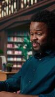 Vertical African american college student feels frustrated and overwhelmed with the learning struggles, worried depressed pupil struggling to memorize information from class notes. Camera A. video