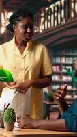 Vertical African American students reading their coursework in a quiet campus library, using academic resources and materials to help with educational development. Study time. Camera A. video