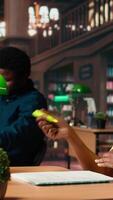 Vertical African american scholar highlighting the relevant information from class notes, creating a summary with highlighter pen. Student underlining key words and phrases from the course. Camera A. video