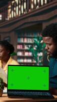 Vertical Scholars preparing for their upcoming exams next to isolated copy space, meeting in a public library and studying together. Students showcasing the educational progress, student life. Camera A. video