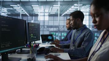 Team of engineers in data center developing and maintaining disaster recovery plans ensuring minimal downtime. Server room workers using data analytics to monitor performance, camera A video