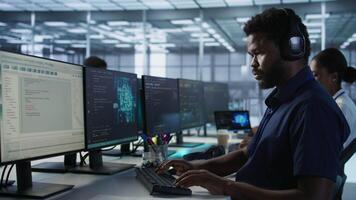 Engineer in data center wearing headphones, implementing AI systems. Server farm expert at desk in office listening music and using artificial intelligence to prevent system failures video
