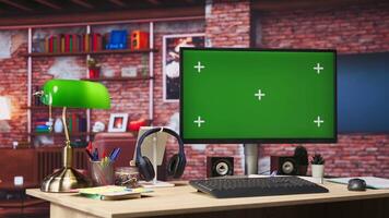 Green screen mockup desktop PC display on cozy home office desk with audio devices. Chroma key computer monitor in colorful modern loft with brick walls and plants on shelves video