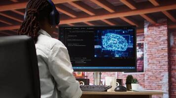 Admin doing maintenance on artificial intelligence neural networks computerized model, listening music. Tech support specialist wearing headphones doing checkup on AI systems, camera A video