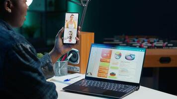Manager in startup office holding teleconference meeting with employees using cellphone, doing performance review. Team leader in online videocall with workers using mobile phone, camera A video