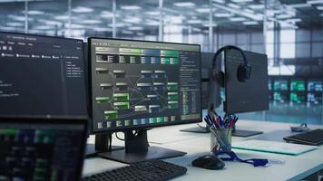 Close up of computer displays in empty data center establishment monitoring hardware energy consumption. PC screens on server hub office desk showing programming software video