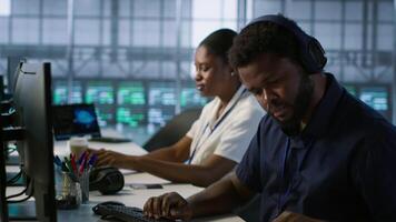 Engineer in server room looking over documents, developing disaster recovery plans ensuring minimal downtime. Worker reading paperwork in data center, using analytics to monitor performance, camera A video