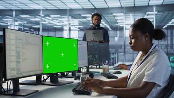 System administrator in server hub ensuring data remains shielded from potential threats using chroma key PC. Woman safeguarding data center against hackers with mockup computer, camera A video