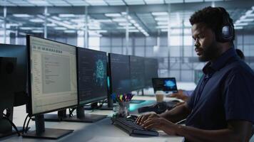 Computer scientist putting headphones on in server room, working to ensure minimal downtime. Engineer using audio device to hear podcasts in data center, monitoring performance, camera A video