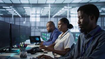 Team leader in server room teaching intern to develop disaster recovery plans ensuring minimal downtime. IT specialist in data center assisting worker in monitoring performance, camera A video