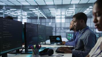 Cheerful server room workers laughing together in office while ensuring minimal downtime. Jolly engineers having fun in data center, using data analytics to monitor performance, camera A video