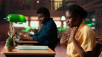Overwhelmed upset girl struggling to study for an upcoming exam, trying to memorize the theoretical notes from the class course at the library. Black college student concerned with her grades. Camera A. video