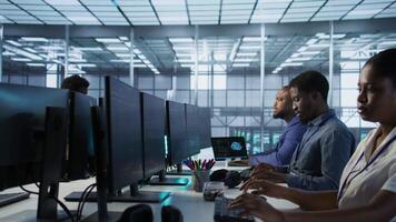Computer scientists in data center implementing AI predictive maintenance systems. Server farm employees using artificial intelligence to identify hardware failures impacting operations, camera A video