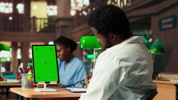 African American pupil learns to become a doctor with a green screen, reading and doing research at the med school library. Student preparing for tests to have a career in healthcare. Camera B. video