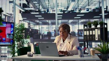 African american CEO driven by empowerment and ambition in her office, focuses on achieving business targets and enhancing company performance in a dynamic corporate setting. Success story. Camera B. video
