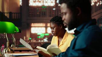 Diligent students reciting poetry together at the campus library, studying for a literature exam. Team of pupils showcasing productivity and commitment for self improvement. Camera B. video