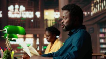 African american college student feels frustrated and overwhelmed with the learning struggles, worried depressed pupil struggling to memorize information from class notes. Camera B. video