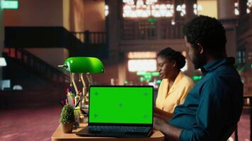Team of students working on a class assignment next to copy space screen, consulting the educational database with books. African american university pupils prepare for exams. Camera A. video