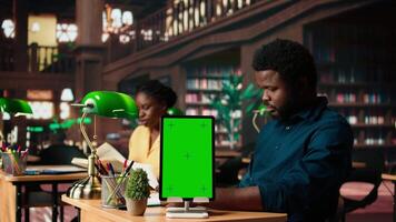 Black college students reading class notes next to copy space screen, studying together at the campus library. Team of pupils working on self improvement and education, study time. Camera A. video